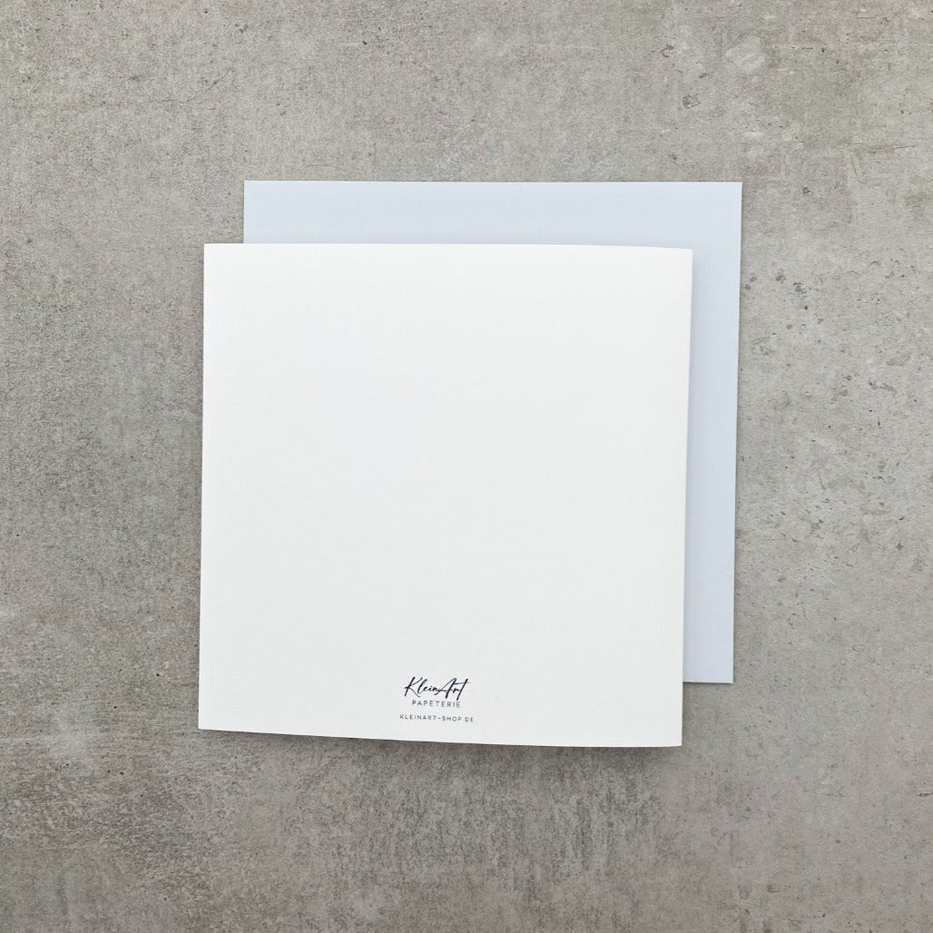 Weeiße Rückseite der Kondolenzkarte mit schwarzem Text "Jedes Wort zu viel und doch zu wenig ♥ wir denken an Euch"