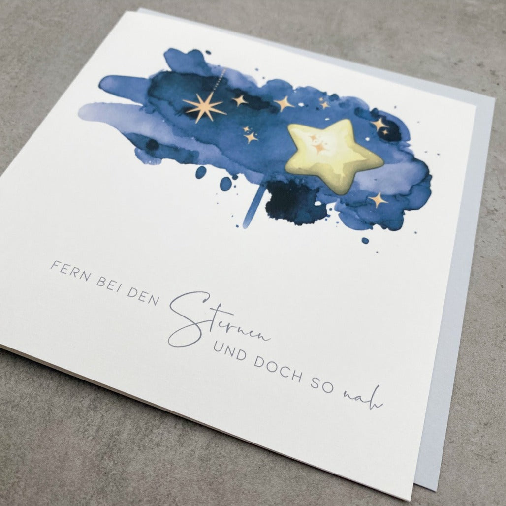 Trauerkarte Sternenkind mit dunkelblauer Zeichnung mit Text "Fern bei den Sternen und doch so nah" mit blaugrauem Umschlag