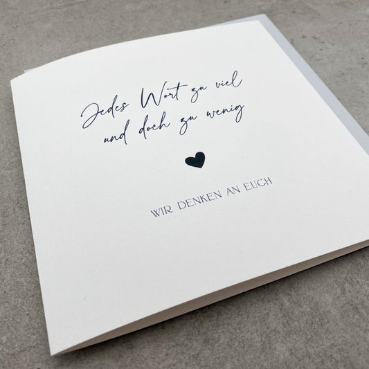 Quadratische weiße Beileidskarte mit schwarzem Text "Jedes Wort zu viel und doch zu wenig ♥ wir denken an Euch"