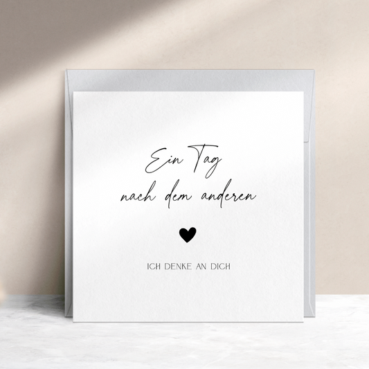 Schlichte Trauerkarte mit schwarzem Text "Ein Tag nach dem anderen ♥ ich denke an Dich" mit blaugrauem Umschlag