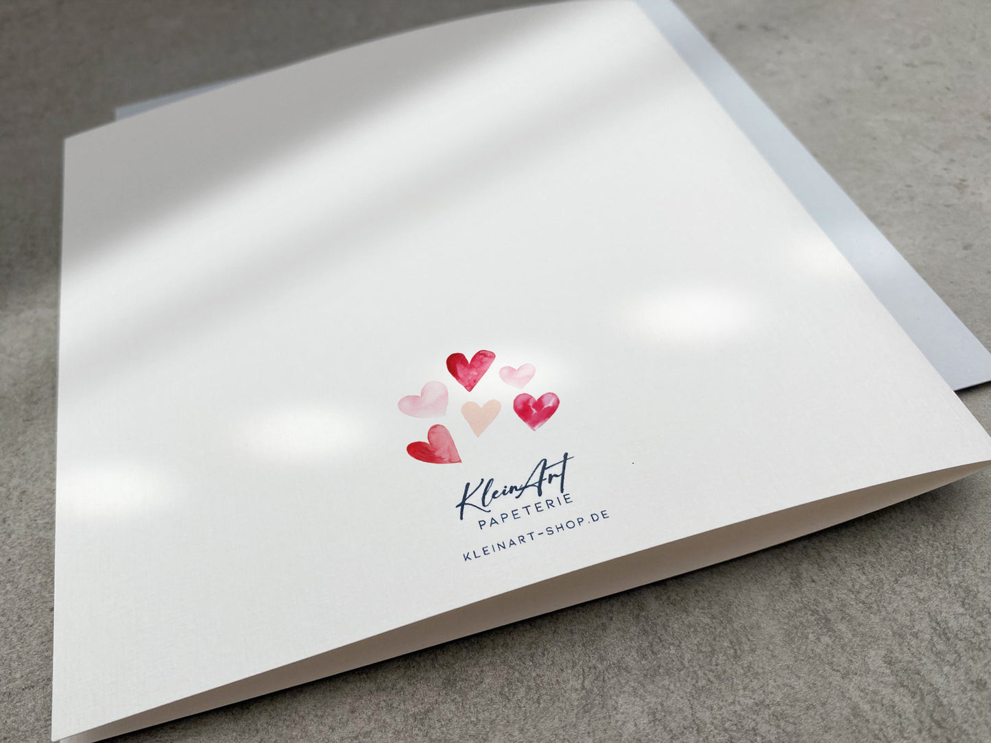 Gratulationskarte zur Geburt mit rosa und roten Aquarell Herzen
