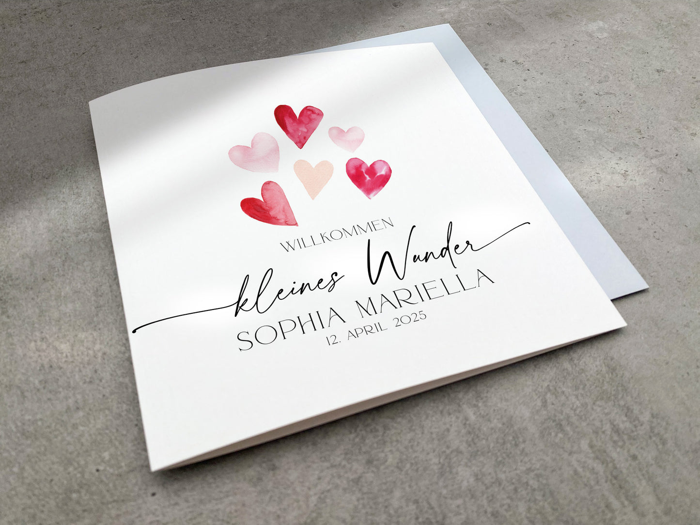 Gratulationskarte zur Geburt mit rosa und roten Aquarell Herzen