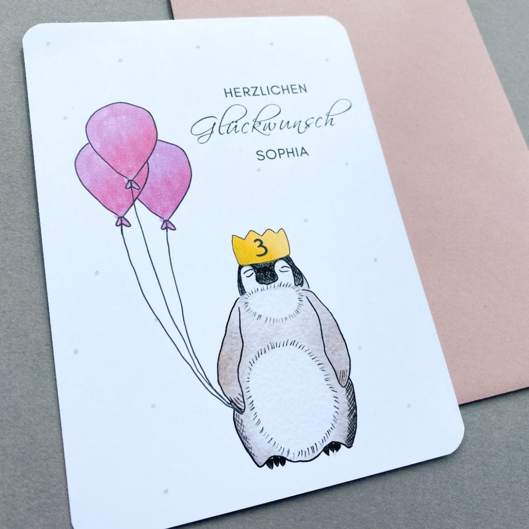 Glückwunschkarte zum Geburtstag mit gezeichnetem Pinguin mit Luftballons und Umschlag