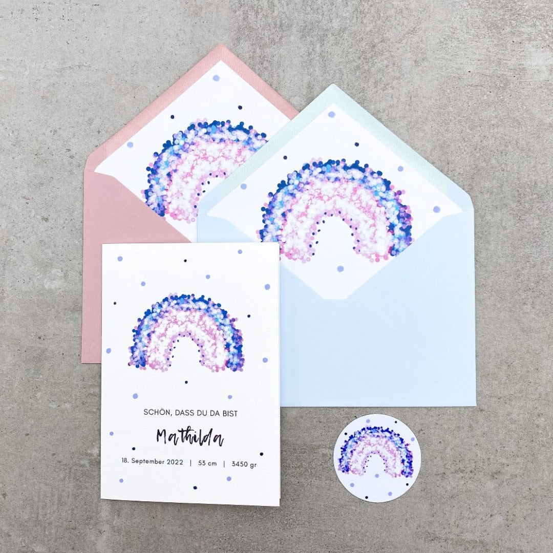 Glückwunschkarte zur Geburt mit lila Regenbogen und rosa oder grauem Umschlag