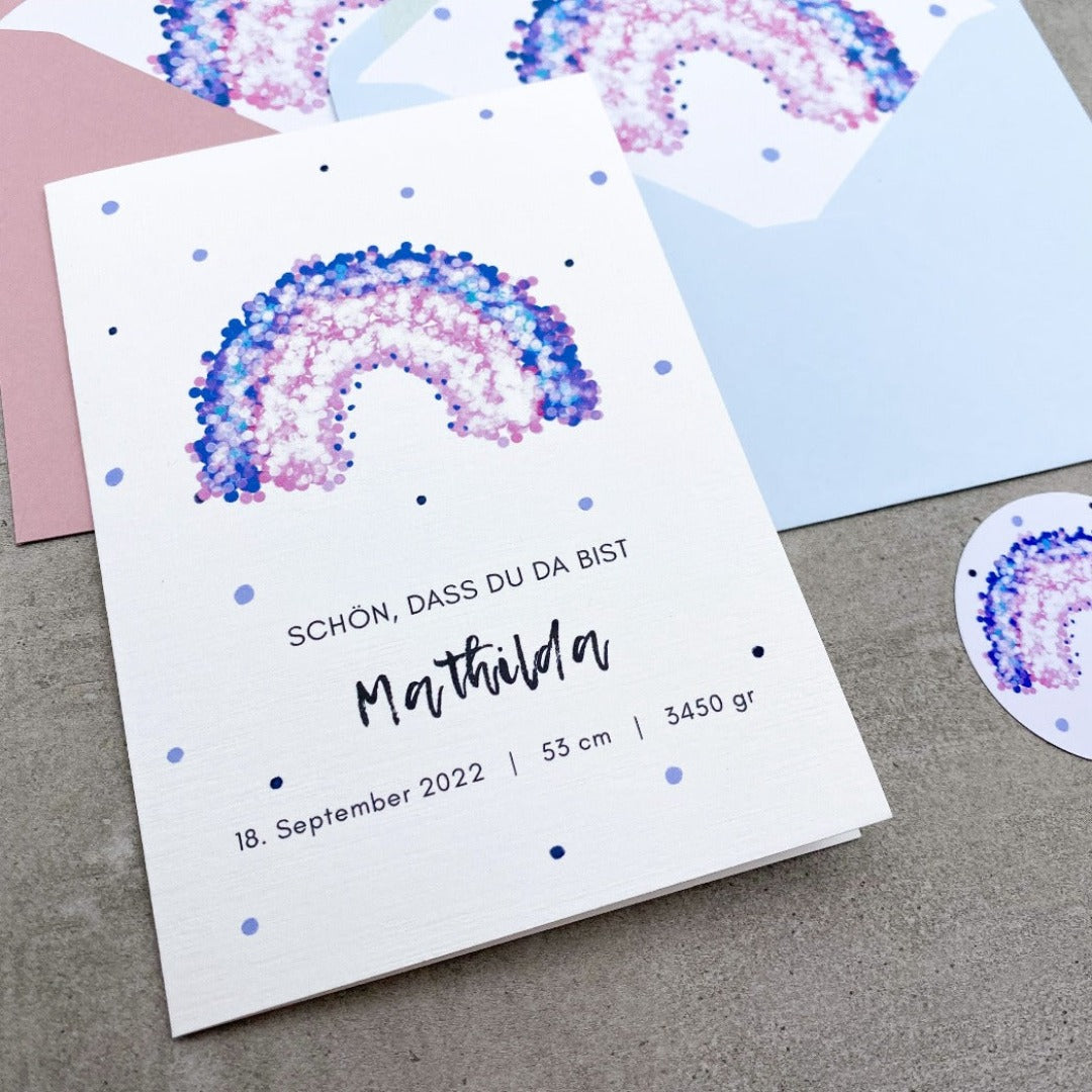 Glückwunschkarte zur Geburt mit lila Regenbogen und Punkten und rosa oder grauem Umschlag