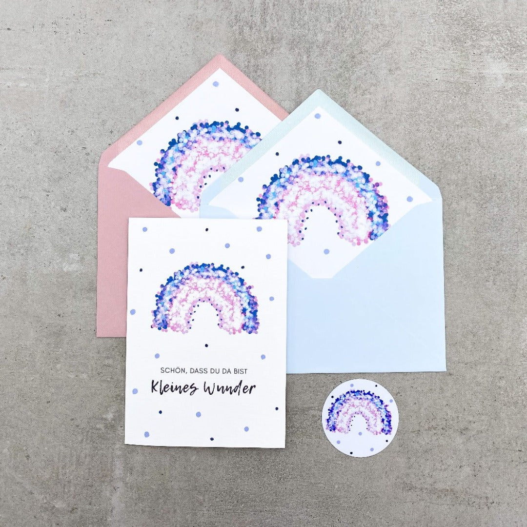 Glückwunschkarte zur Geburt mit lila Regenbogen und rosa oder grauem Umschlag