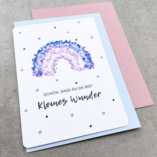 Glückwunschkarte zur Geburt mit lila Regenbogen und rosa oder grauem Umschlag